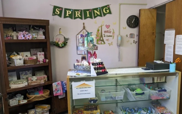 A small shop decorated with spring-themed items, featuring a display case with various goods.