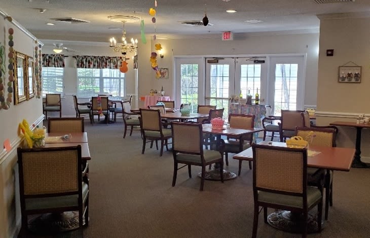 A cozy dining area with tables and chairs arranged neatly, featuring hanging decorations.