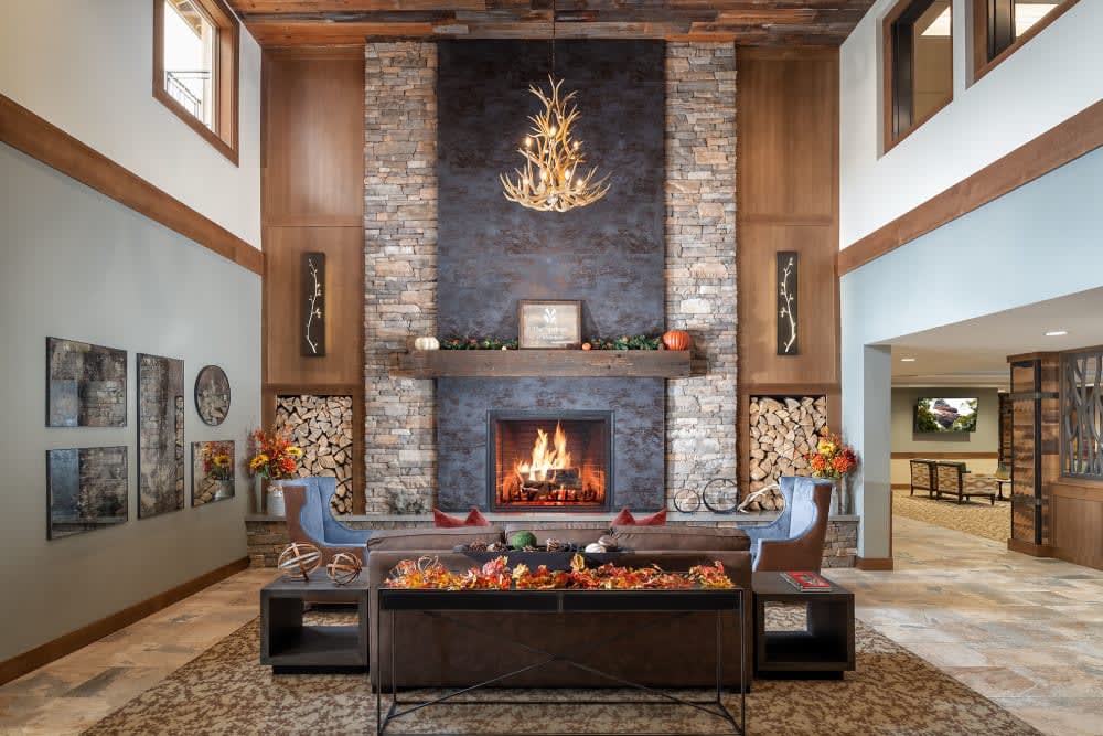 A cozy living room with a stone fireplace and rustic decor.