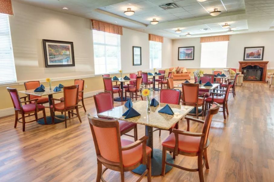 An empty dining area with neatly arranged tables and chairs, featuring warm lighting and decor.