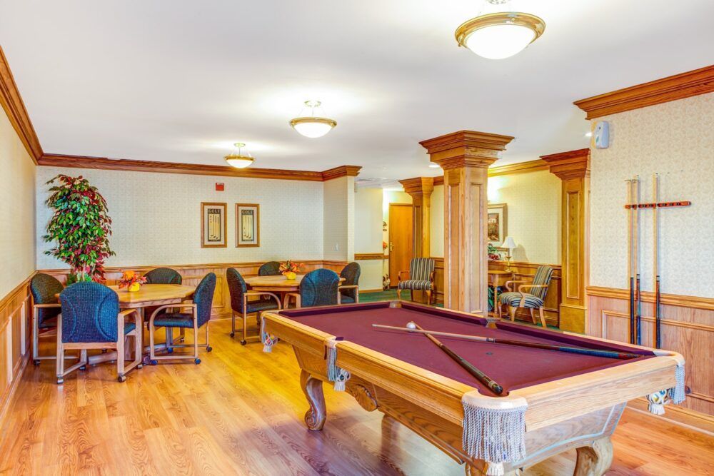 A well-lit game room featuring a pool table and seating area.