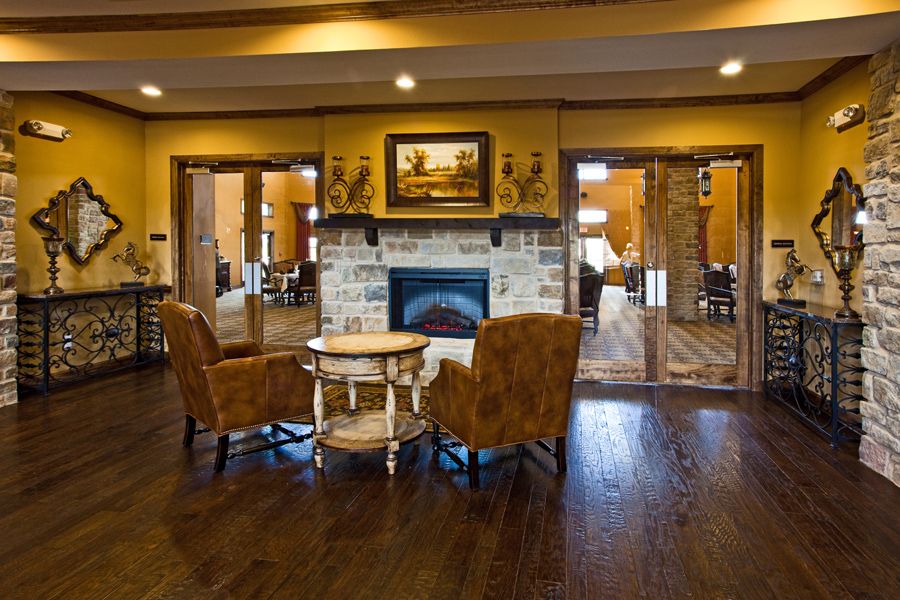 A cozy lounge area with a fireplace and two chairs facing each other.
