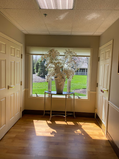 A bright and inviting hallway with a decorative vase of flowers by the window.
