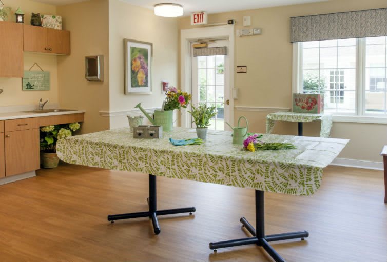 A bright community room with decorated tables and fresh flowers.