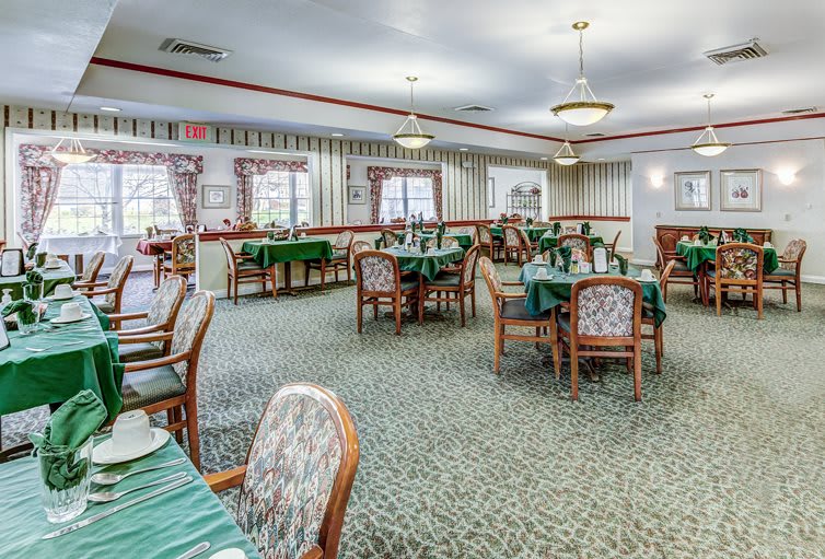 A formal dining room with neatly arranged tables and chairs, ready for guests.