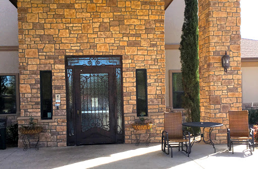 A welcoming entrance featuring a stylish black door and stone wall.