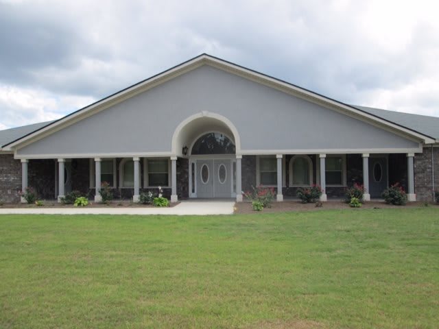 A single-story house with a wide porch and front lawn.