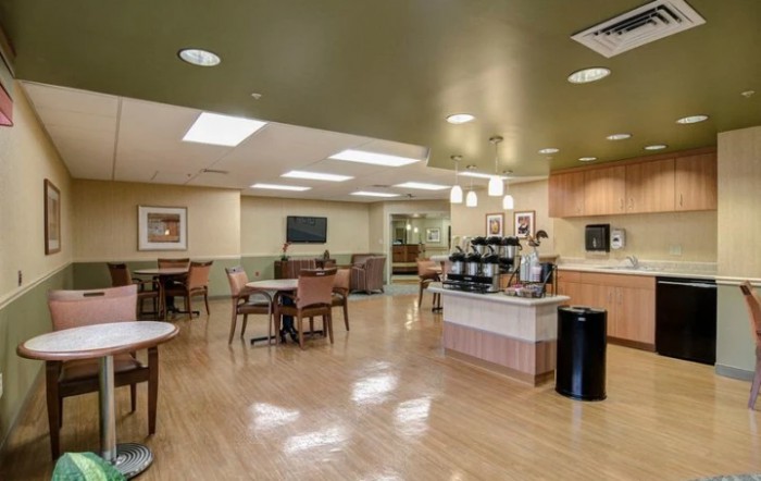 A spacious and modern cafe interior with seating and a coffee station.