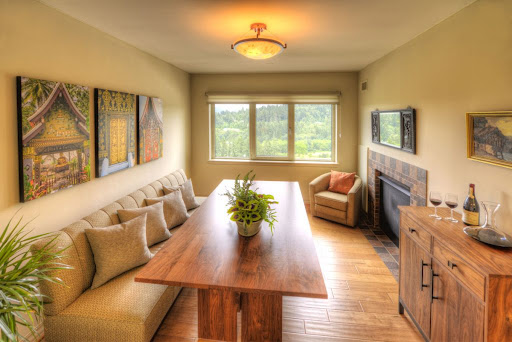 A cozy dining area featuring a wooden table, comfortable seating, and a beautiful view of the outdoors.