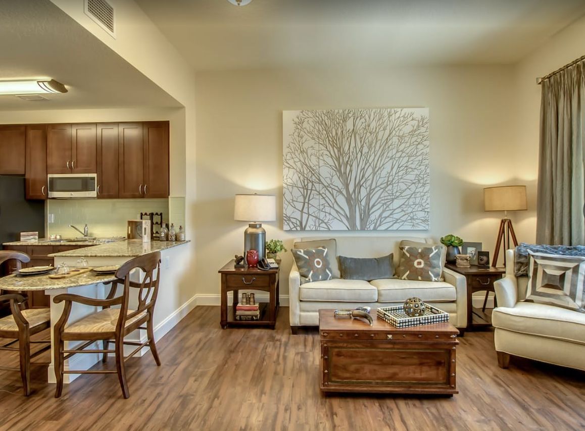 A cozy and modern living room with a neutral color palette, featuring a sofa, coffee table, and decorative wall art.