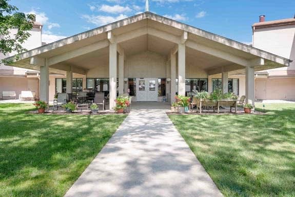 A symmetrical building with a large entrance, surrounded by green lawns and a clear sky.