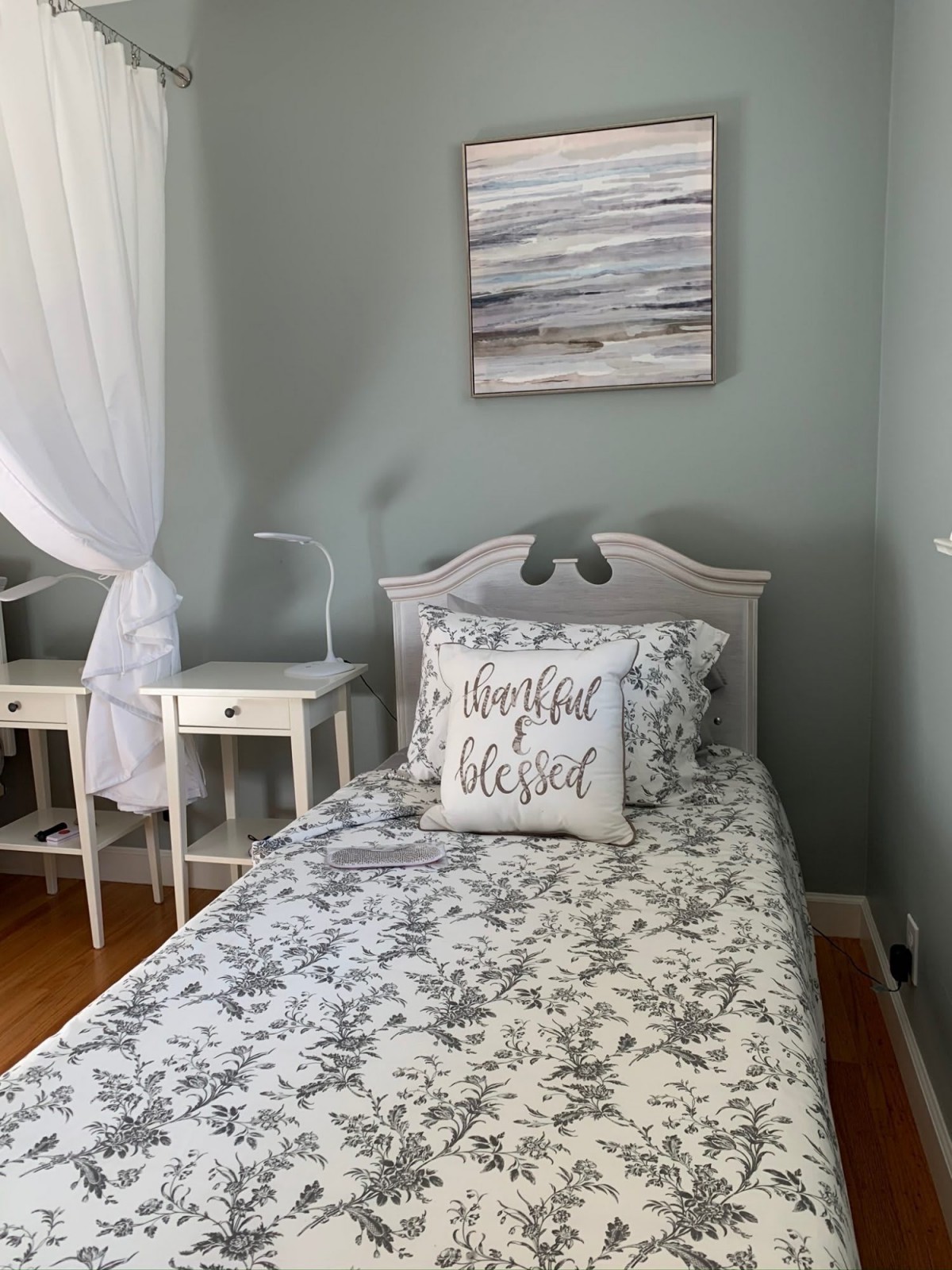 A cozy bedroom with a neatly made bed, decorative pillows, and matching nightstands.