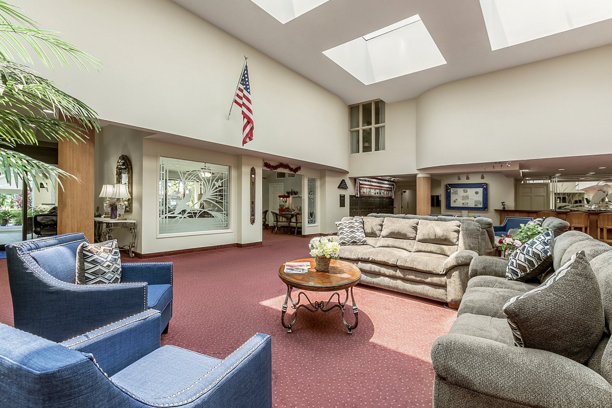 A spacious lobby area featuring comfortable seating, skylights, and an American flag.