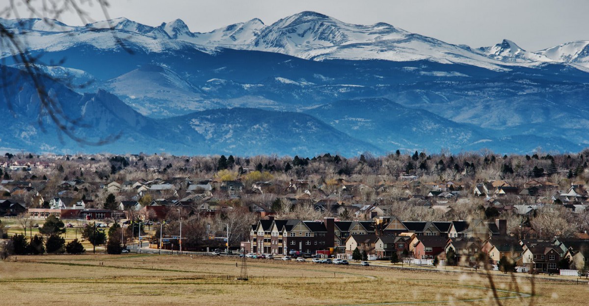 A picturesque town nestled at the foot of snow-capped mountains.