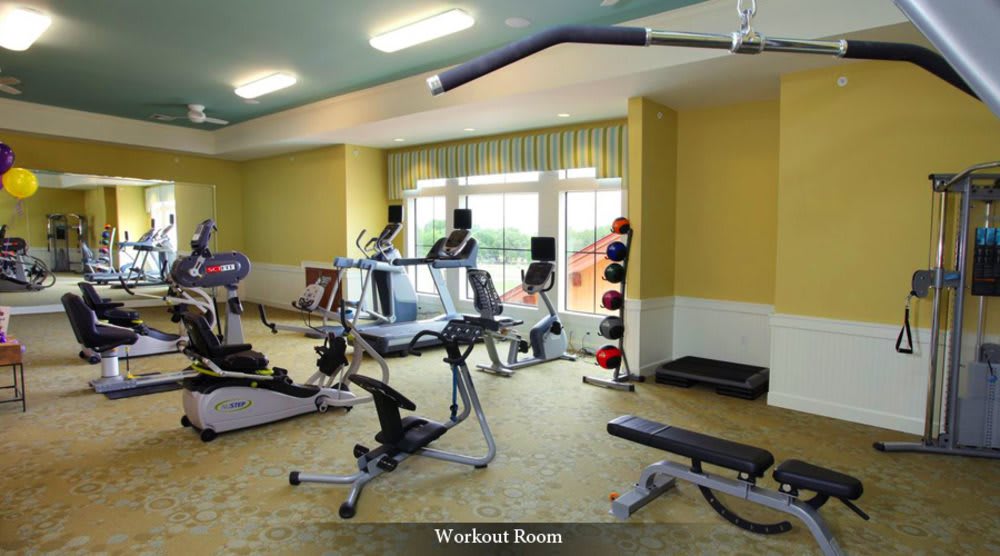 A modern workout room equipped with various exercise machines and weights.