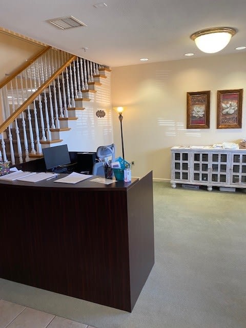 A welcoming reception area with a desk and staircase, creating an inviting office environment.
