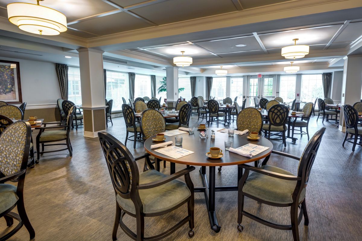 An elegant, empty dining room with neatly arranged tables and chairs.