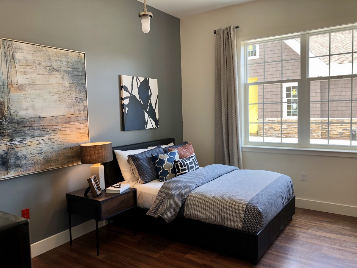 A modern bedroom interior with stylish decor and a neatly made bed.