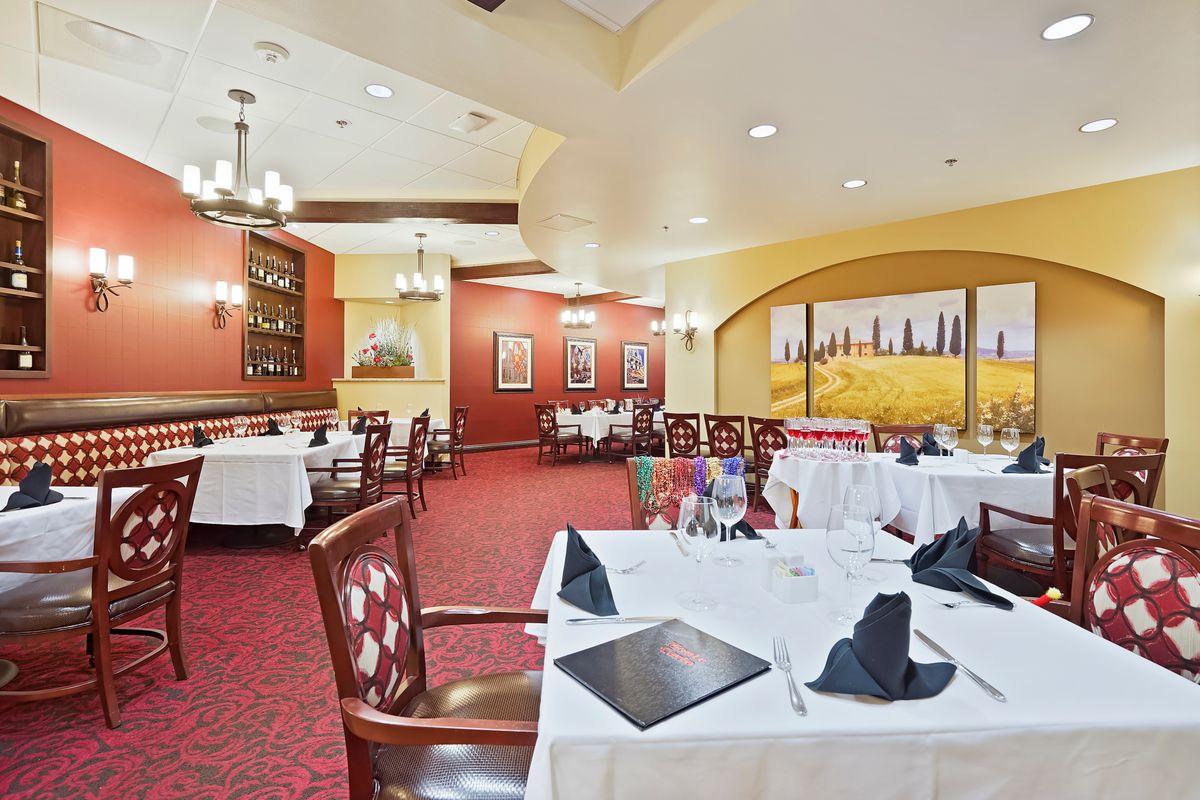 A beautifully set dining area in an elegant restaurant with neatly arranged tables and chairs.