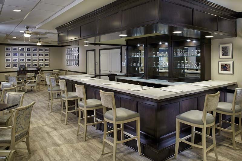 A modern bar interior with a sleek counter and seating arrangement.