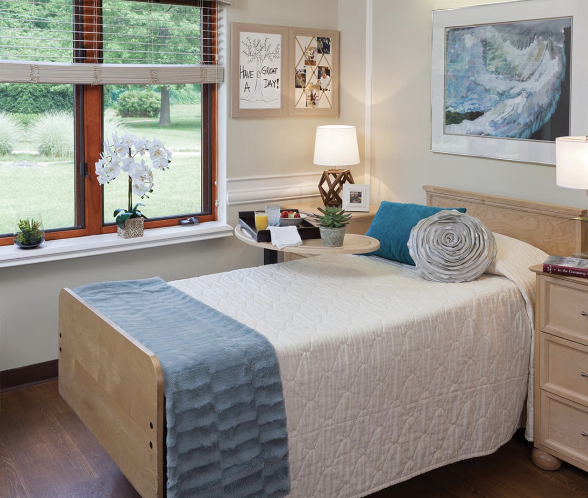 A cozy bedroom with a neatly made bed, a lamp on the bedside table, and an orchid by the window.