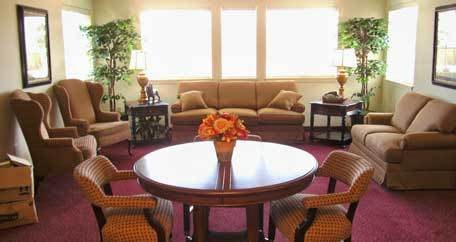 A cozy living room with a central table and comfortable seating.