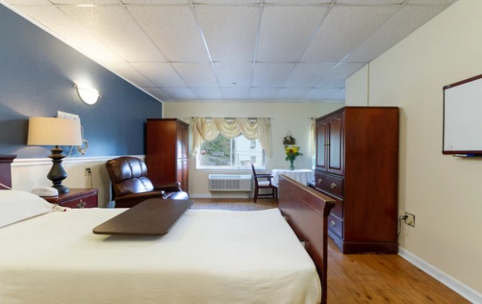 A cozy bedroom with wooden furniture and ample natural light.