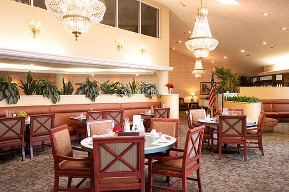 An elegant dining area featuring stylish chandeliers and neatly arranged tables.