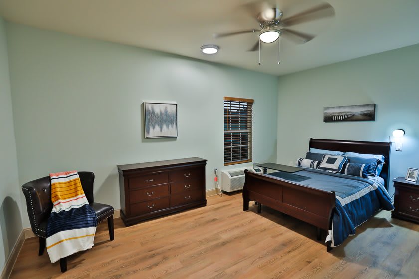 A cozy bedroom with a wooden bed, dresser, and modern decor.