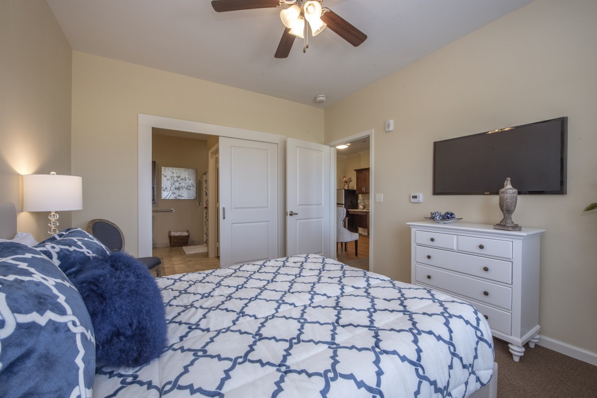 A cozy bedroom with a patterned bedspread and modern furnishings.