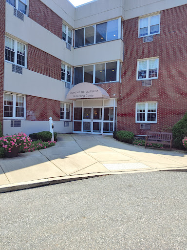 A view of the entrance to a brick building with a landscaped area.