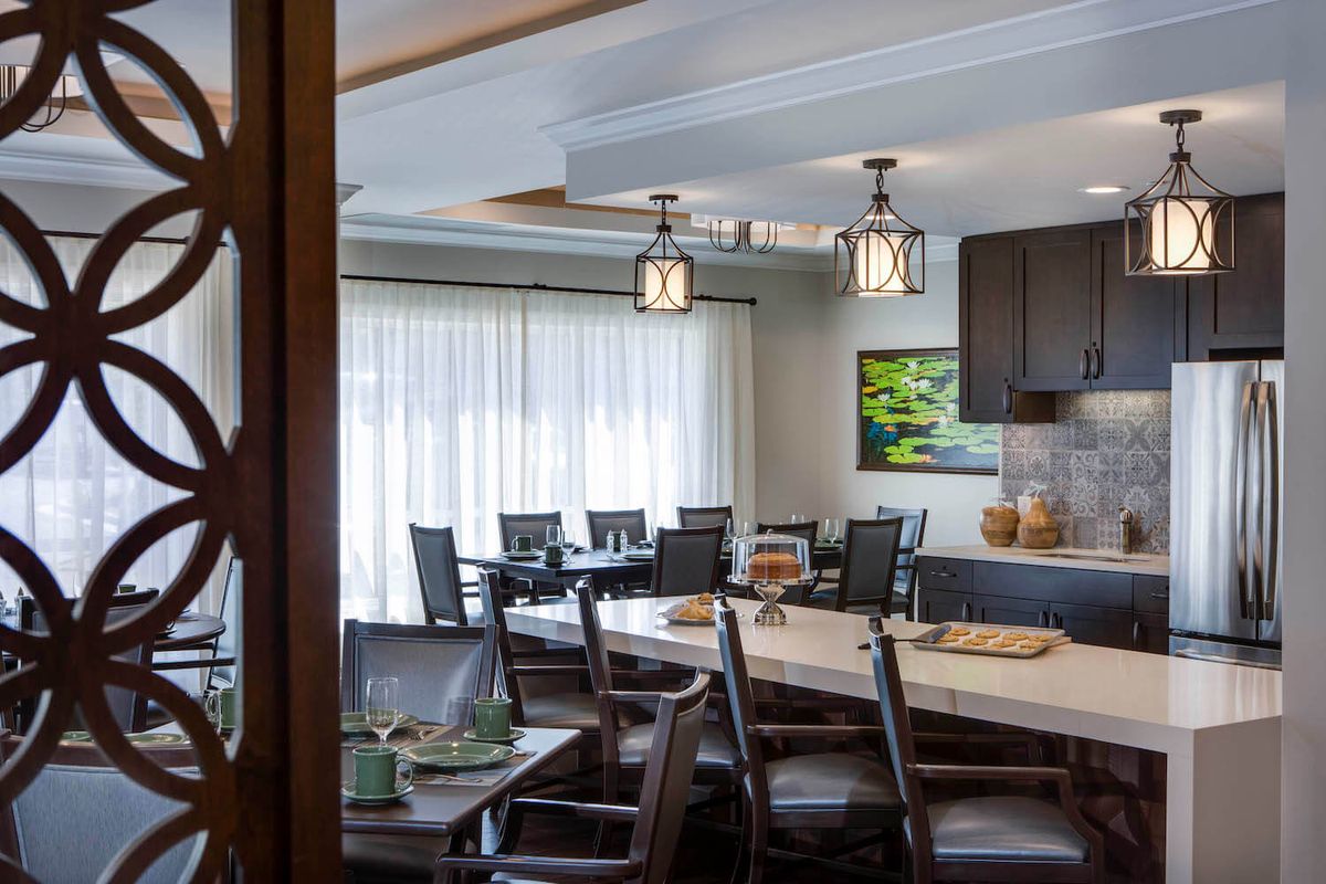 A modern dining room with elegant lighting and spacious seating.