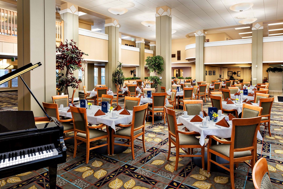 An elegant dining area with arranged tables and chairs, set for guests.