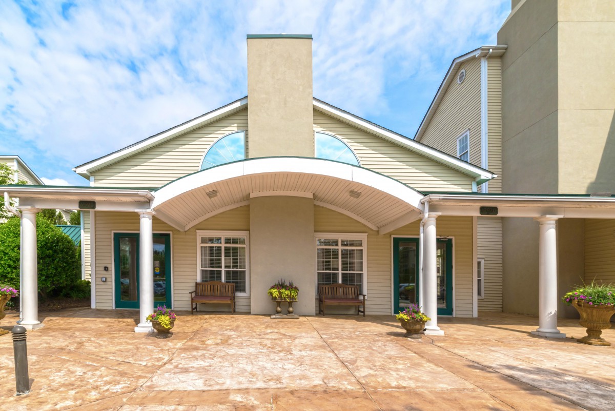 A modern building entrance with an arched roof and potted plants.