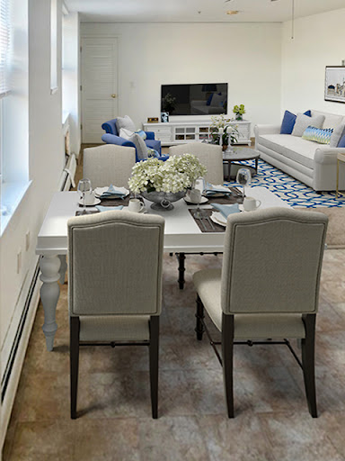 A cozy and modern living space featuring a dining table set for meals, a stylish sofa, and a television for entertainment.