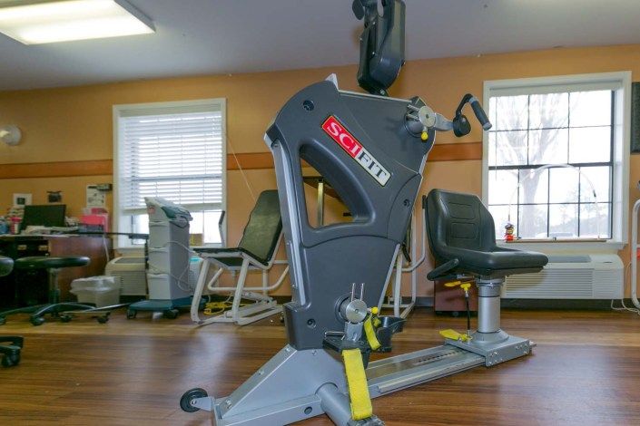 A gym setup featuring an exercise machine and rehabilitation equipment in a fitness room.