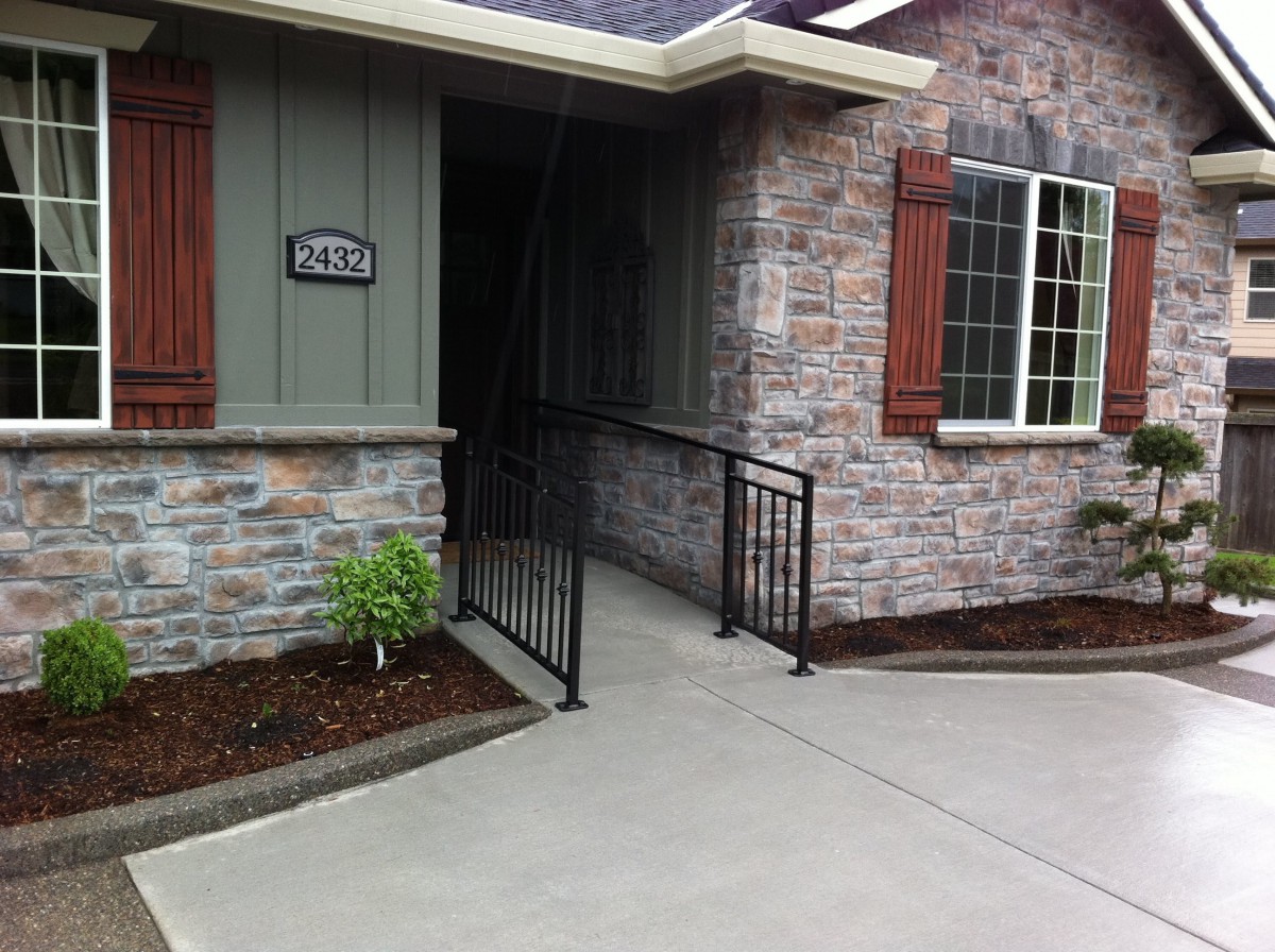 A house entrance with a wheelchair-accessible ramp and brick wall exterior.