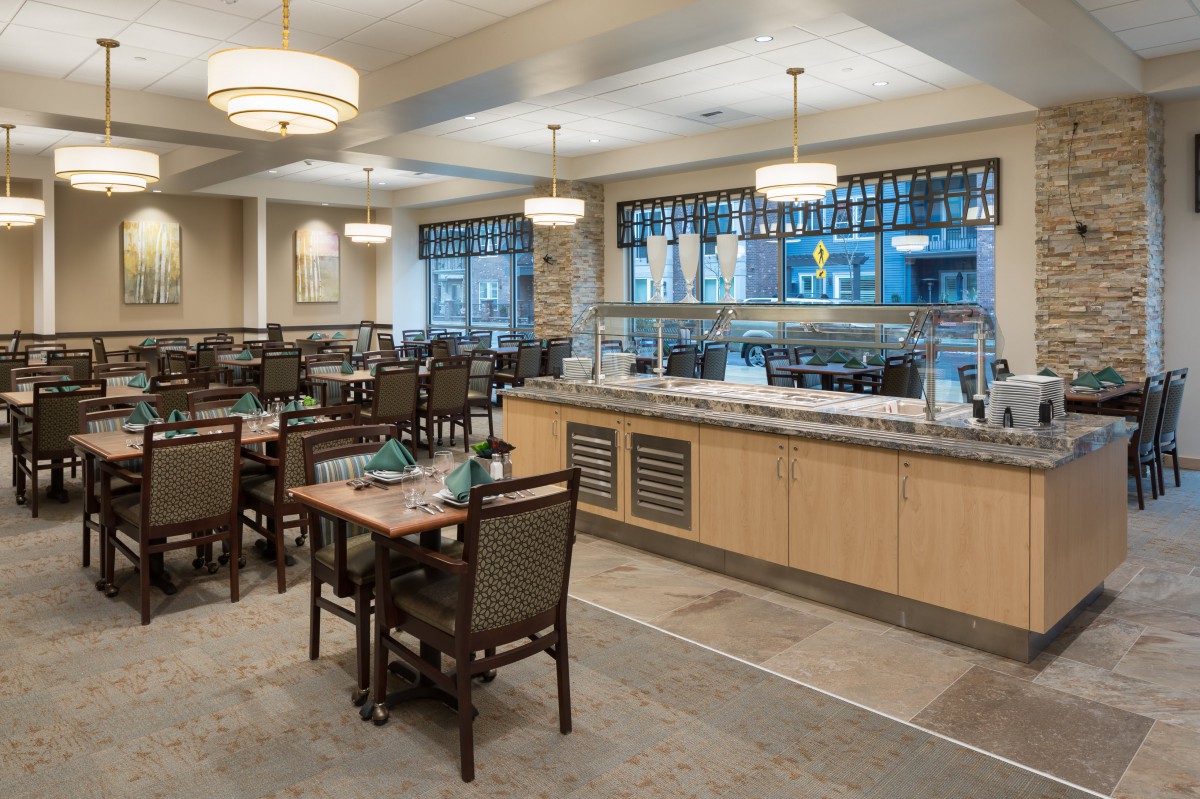 An elegant indoor dining area with neatly arranged tables and a buffet counter.