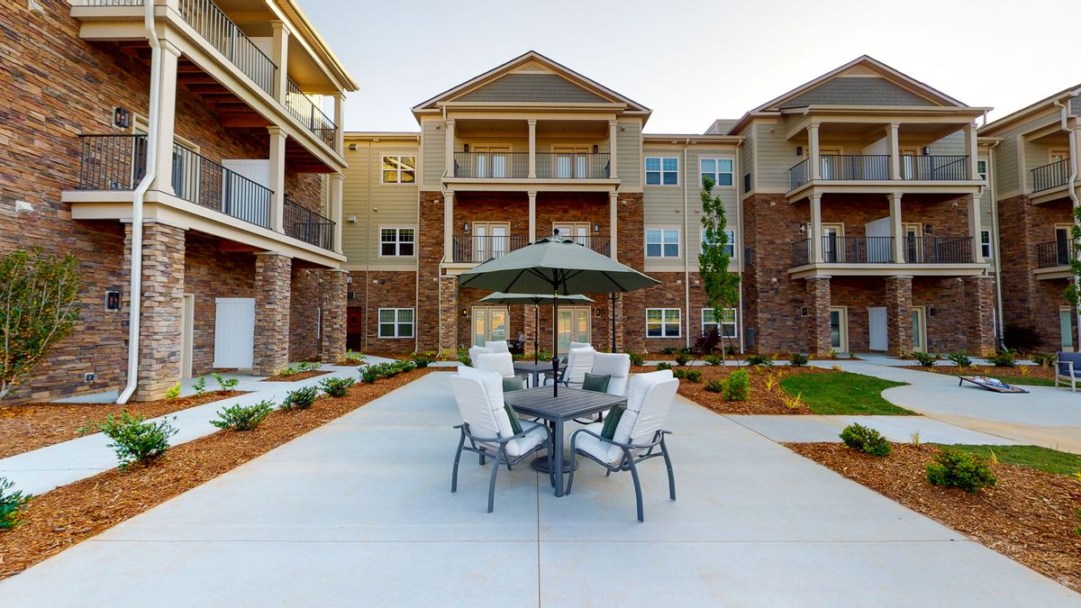 Modern apartment building with a furnished outdoor patio area.