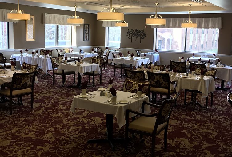 An elegantly decorated dining room with neatly arranged tables and chairs, ready for guests.