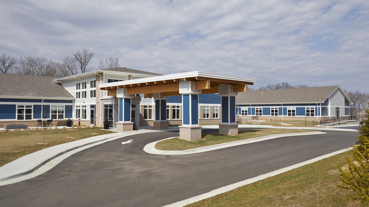 A modern building with a covered entrance and driveway.