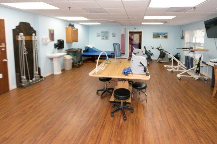 A well-equipped physical therapy room featuring exercise equipment and treatment areas.