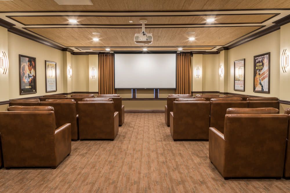A cozy home theater room with leather seating and a large projection screen.