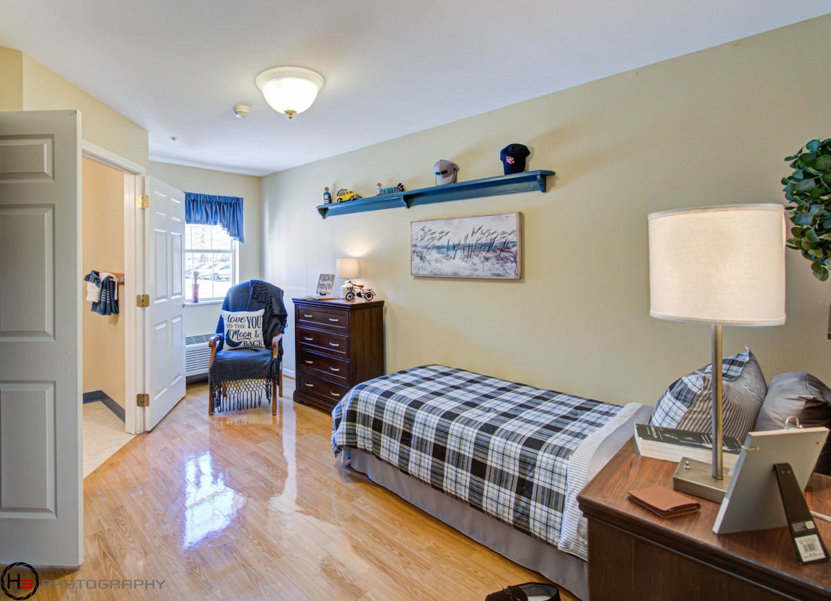 A cozy bedroom with a single bed, wooden floors, and tasteful decor.