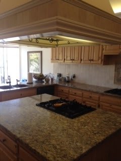 A spacious kitchen with wooden cabinets and a large countertop.