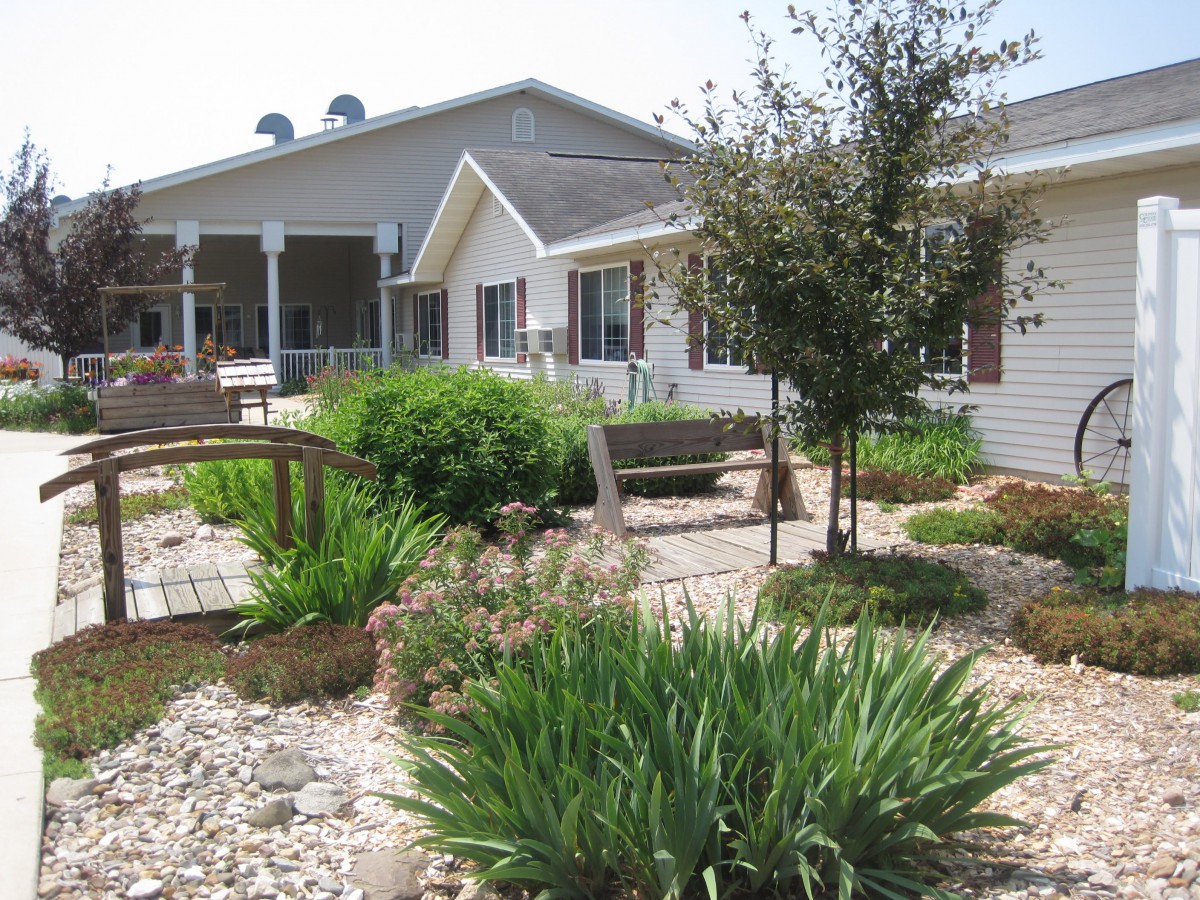 A beautifully landscaped garden with lush greenery in front of a house.