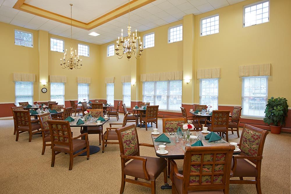 Elegant dining room with neatly arranged tables and chandeliers.