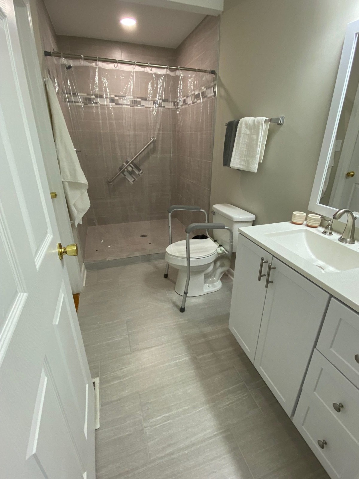 A modern bathroom with a shower, toilet, and sink.