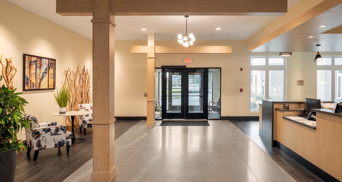 A modern lobby entrance featuring double glass doors and a stylish chandelier.