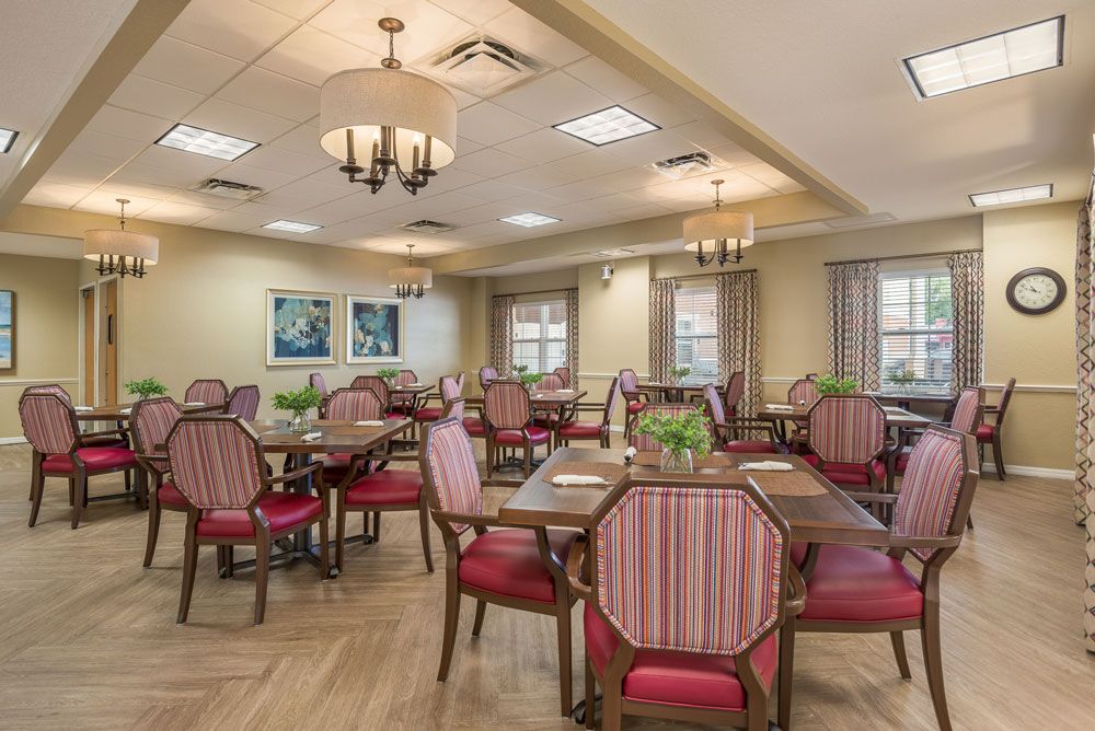 A well-decorated dining area featuring multiple tables and chairs with elegant lighting fixtures.